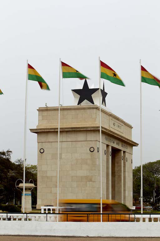 Ghanian flags waving on top of the Freedom and Justice Arch